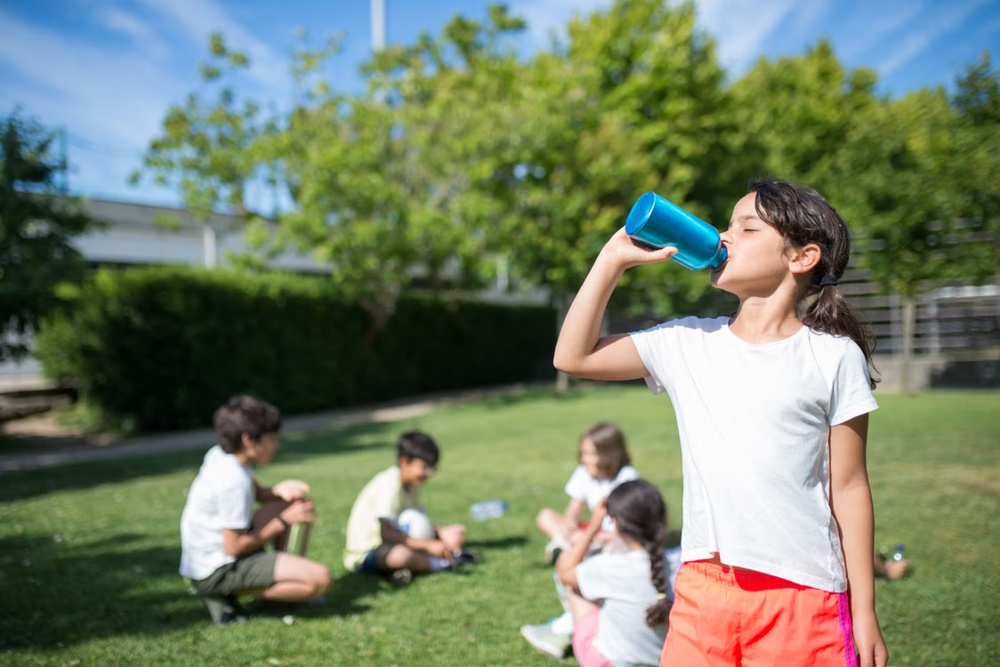 Children drinking water outdoors