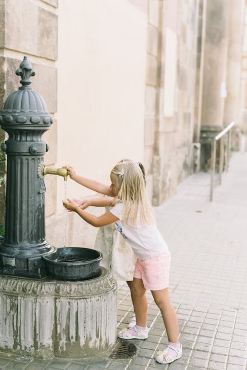 Child using an outdoor drinking fountain